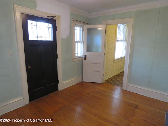 entryway with hardwood / wood-style floors and ornamental molding