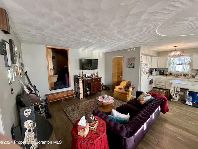 living room with wood-type flooring, a chandelier, and a textured ceiling