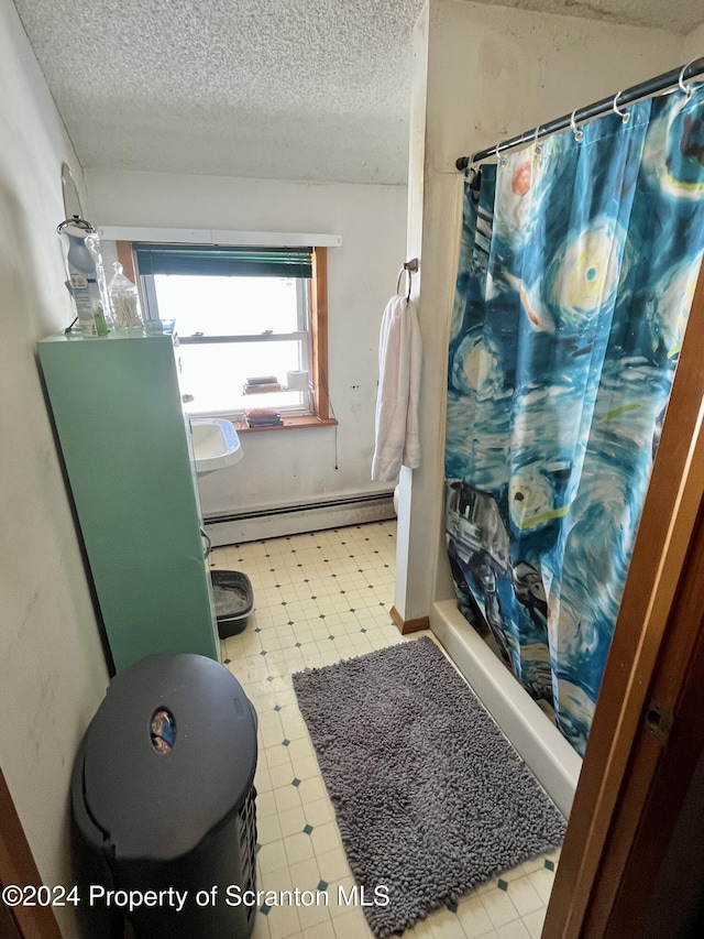 bathroom featuring a baseboard heating unit, curtained shower, and a textured ceiling