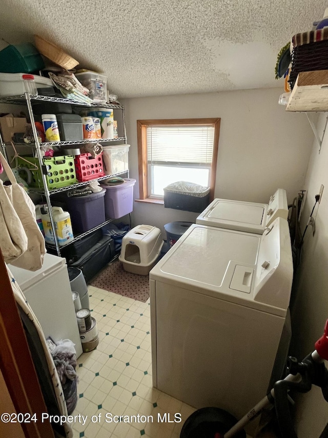 washroom featuring washer and clothes dryer and a textured ceiling