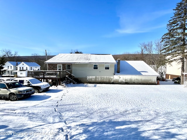 view of snow covered back of property