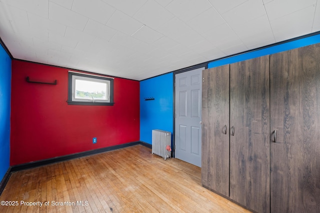 730 Chase Rd, Shavertown, PA 18708 - unfurnished bedroom with radiator heating unit, light wood finished floors, and baseboards
