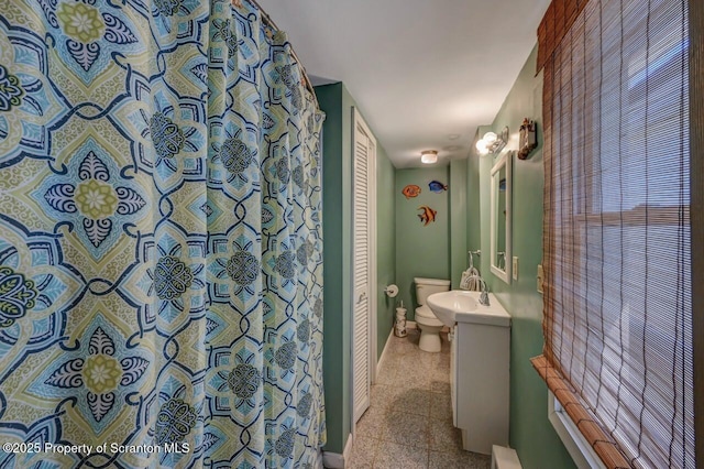 bathroom featuring baseboards, vanity, and toilet