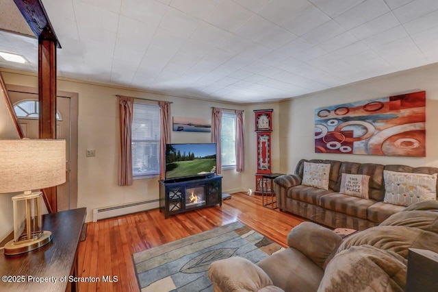 living area with baseboard heating and hardwood / wood-style flooring