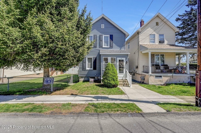 view of front of house featuring fence, covered porch, and a front yard