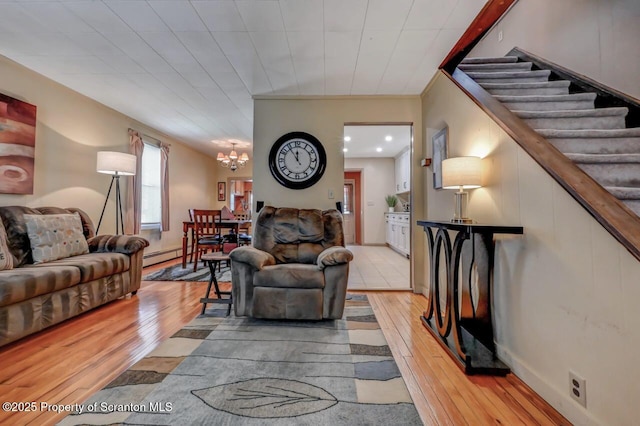 living room featuring an inviting chandelier, recessed lighting, light wood-style flooring, and a baseboard heating unit
