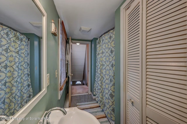 full bath with a closet, a sink, and wallpapered walls