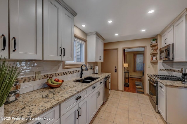 kitchen with decorative backsplash, open shelves, recessed lighting, a sink, and appliances with stainless steel finishes