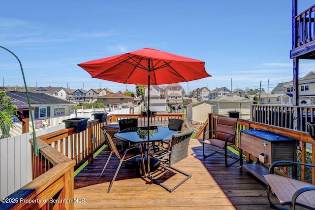 wooden deck with a residential view and outdoor dining space