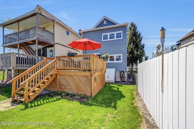 back of house with a lawn, a deck, stairway, and fence