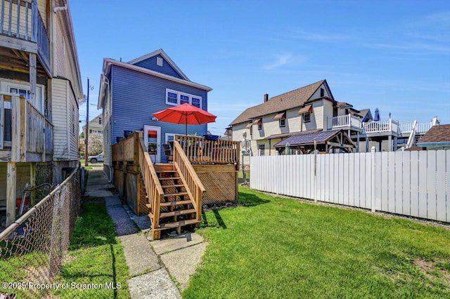 view of yard with fence, a deck, and stairway