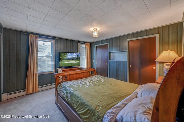 carpeted bedroom featuring wooden walls