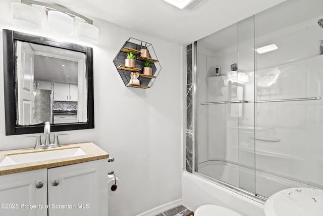 bathroom featuring baseboards, shower / bath combination with glass door, vanity, and toilet