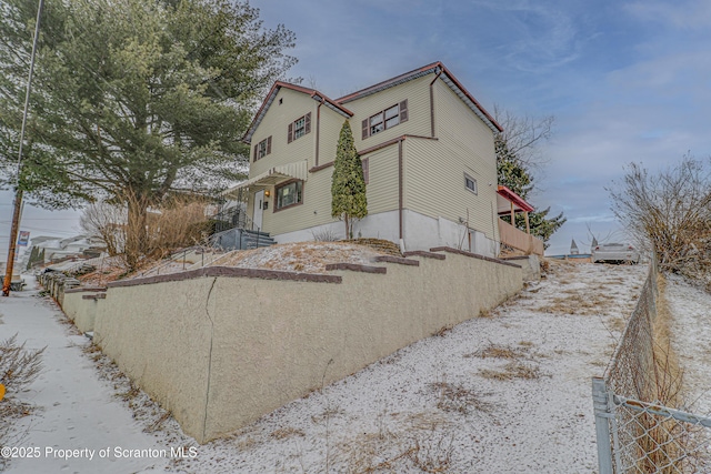 view of snowy exterior with fence