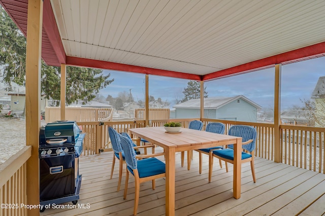 wooden deck featuring a grill and outdoor dining space