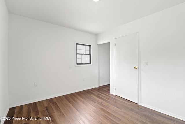 unfurnished bedroom featuring baseboards and wood finished floors