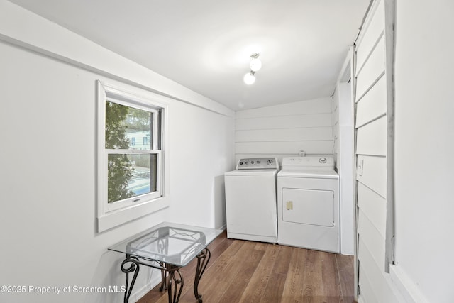 clothes washing area featuring laundry area, independent washer and dryer, and wood finished floors