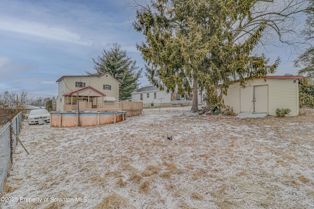 view of yard featuring a shed, fence, a fenced in pool, and an outbuilding