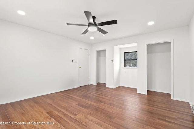 unfurnished bedroom featuring ceiling fan, recessed lighting, baseboards, multiple closets, and dark wood finished floors