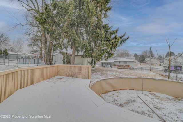 yard layered in snow featuring a residential view and a deck