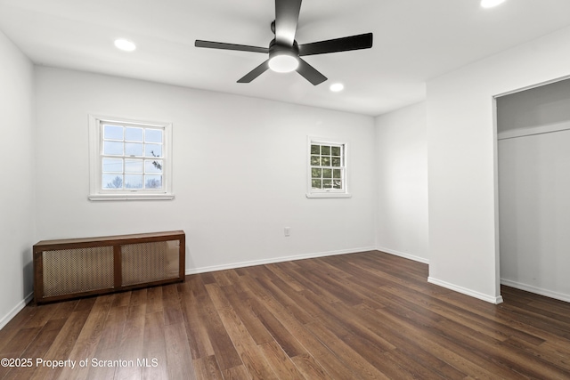 unfurnished bedroom featuring baseboards, a ceiling fan, radiator, dark wood-style floors, and recessed lighting