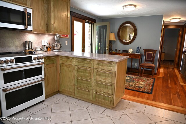 3511 Liberty Park Rd, Hallstead, PA 18822 - kitchen featuring white appliances, a peninsula, light countertops, tasteful backsplash, and light tile patterned floors