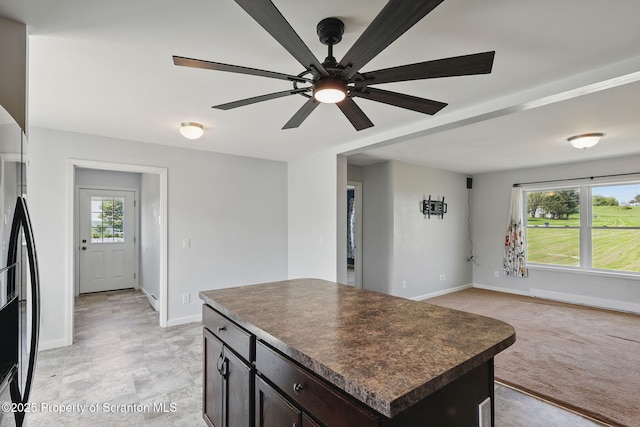 960 Lott Rd, Meshoppen, PA 18630 - kitchen with dark countertops, baseboards, a ceiling fan, dark brown cabinets, and a center island
