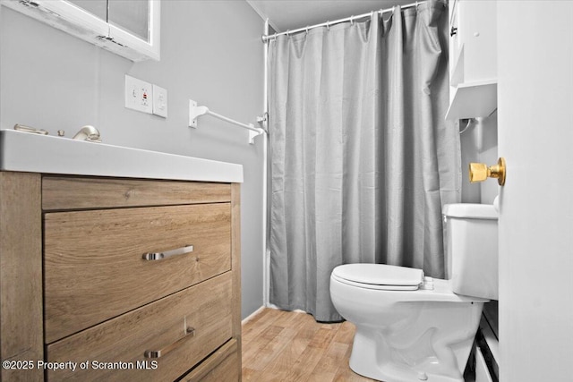 bathroom featuring hardwood / wood-style flooring, toilet, and walk in shower