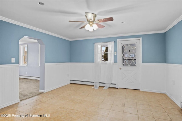 tiled empty room featuring ceiling fan, a baseboard heating unit, and crown molding