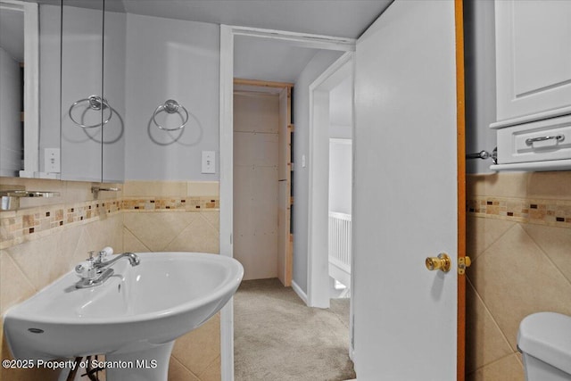 bathroom featuring sink, toilet, and tasteful backsplash