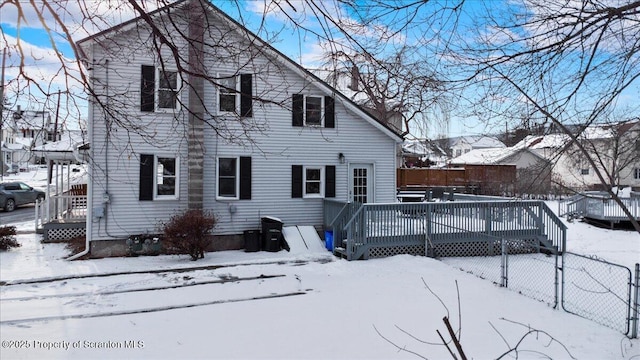 snow covered house featuring a deck