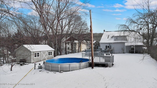 snow covered pool featuring a deck and a storage unit