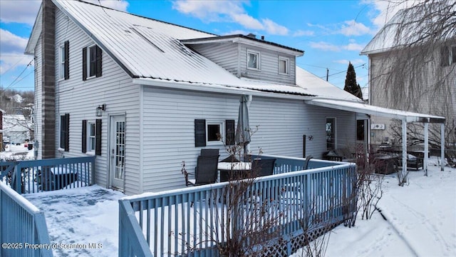 snow covered property with a wooden deck