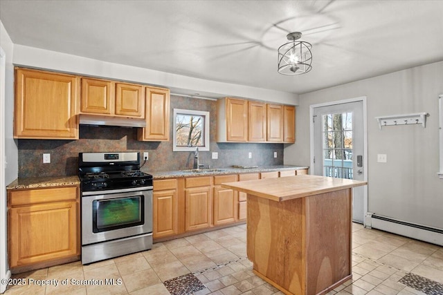 kitchen featuring a center island, stainless steel gas stove, sink, hanging light fixtures, and decorative backsplash