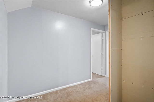 interior space featuring light colored carpet and vaulted ceiling