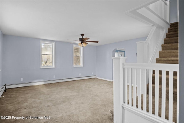 empty room with ceiling fan, carpet floors, and a baseboard heating unit