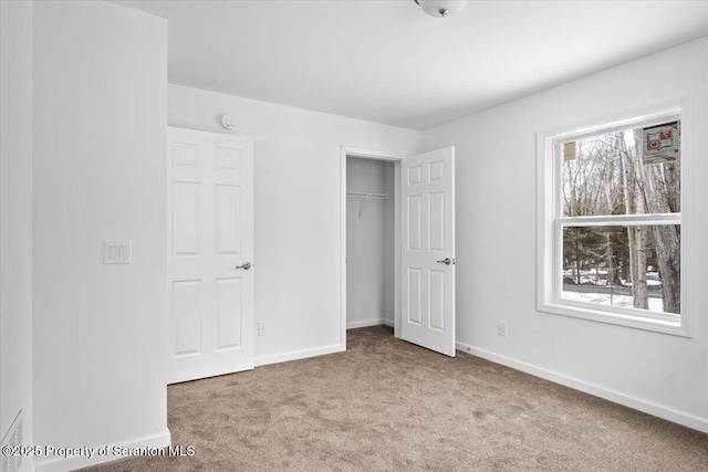 unfurnished bedroom with light carpet and a closet