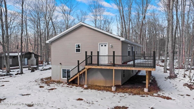 snow covered rear of property featuring a deck