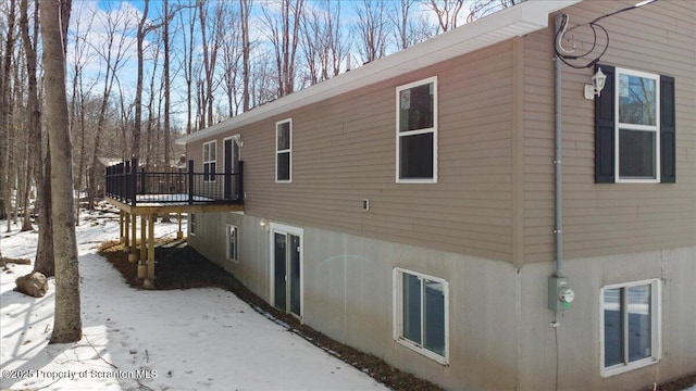 view of snowy exterior with a wooden deck