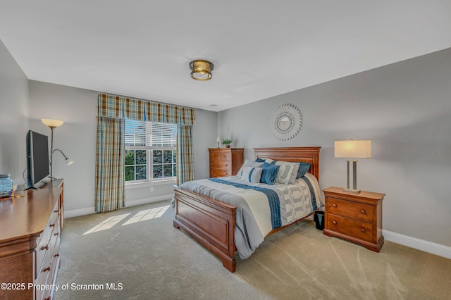 bedroom featuring light colored carpet and baseboards