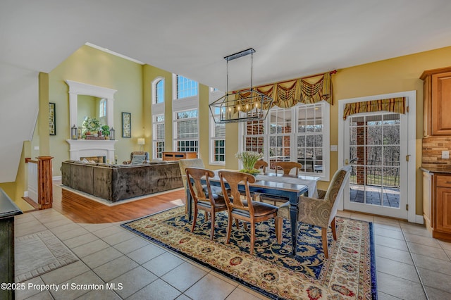 dining room featuring a healthy amount of sunlight, light tile patterned floors, and an inviting chandelier