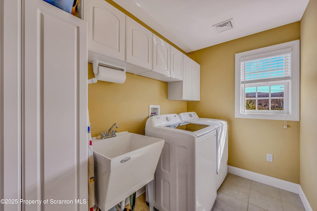 clothes washing area featuring visible vents, light tile patterned flooring, a sink, washer and dryer, and cabinet space