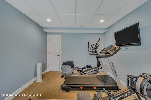 workout room featuring baseboards, recessed lighting, and a drop ceiling