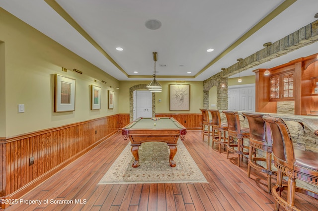 playroom with wood-type flooring, wainscoting, a tray ceiling, and billiards