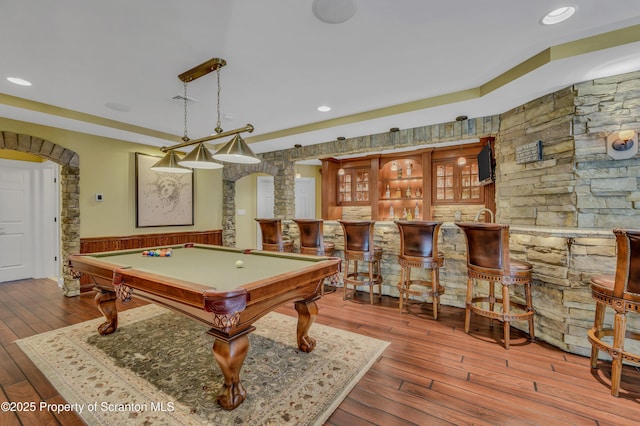 playroom featuring pool table, indoor wet bar, ornate columns, arched walkways, and wood-type flooring