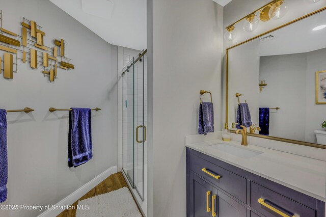 full bath featuring a shower stall, vanity, visible vents, and baseboards