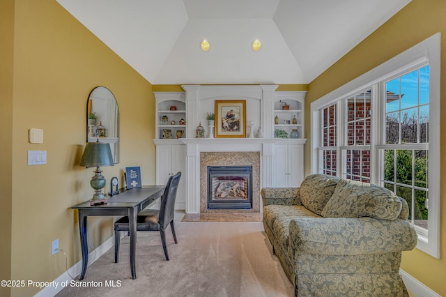 interior space featuring a fireplace with flush hearth, baseboards, and vaulted ceiling