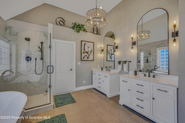 full bathroom featuring a chandelier, two vanities, a shower stall, and a sink