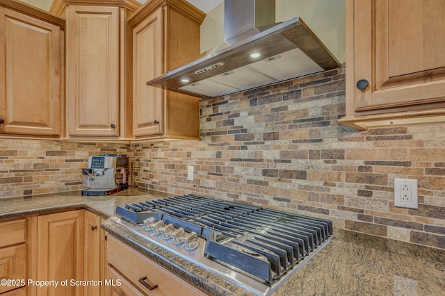 kitchen featuring stainless steel gas cooktop, tasteful backsplash, light brown cabinets, and wall chimney range hood