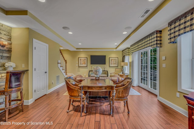 dining room with wood finished floors, visible vents, and stairs